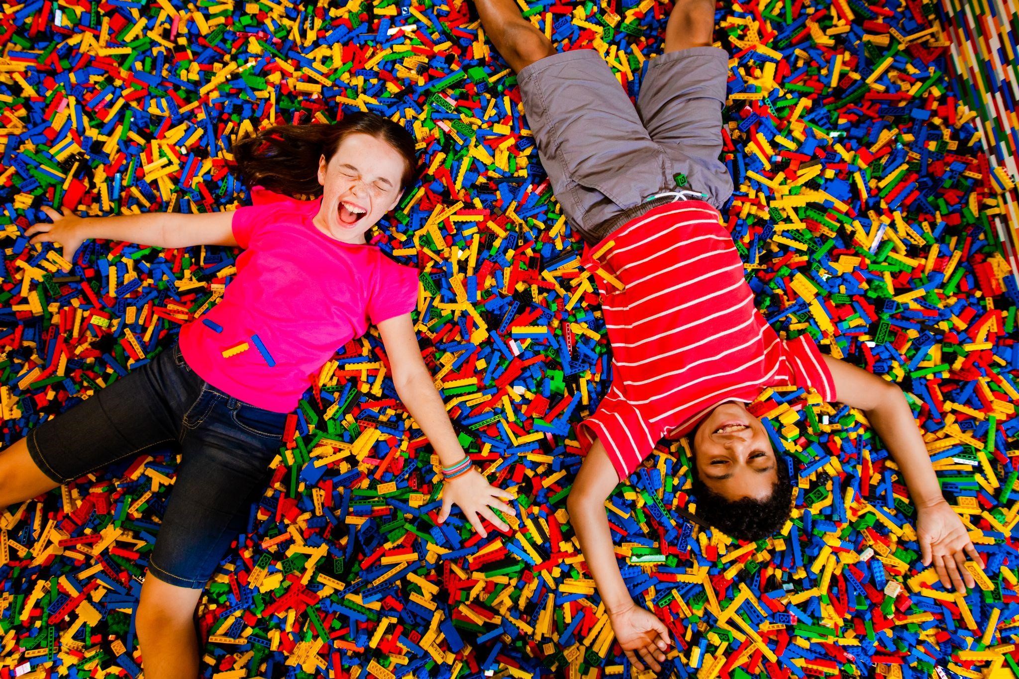 two kids laughing in a lego pit
