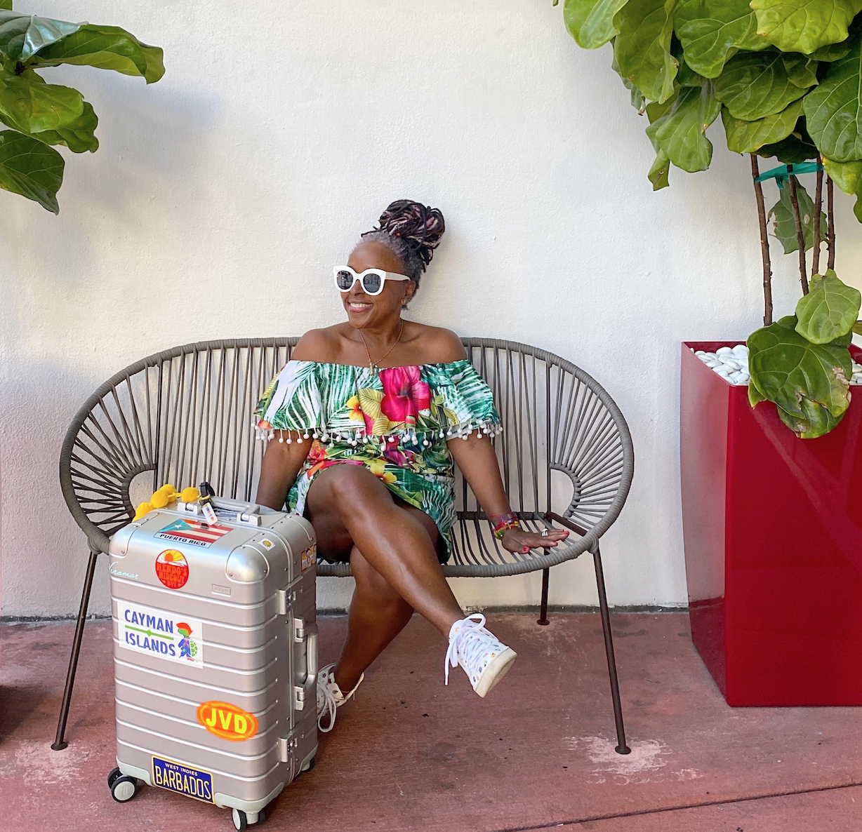 Sarah  sitting on a chair with a suitcase near her