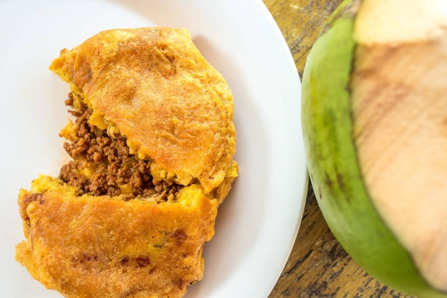a Piñone on a white plate next to a coconut
